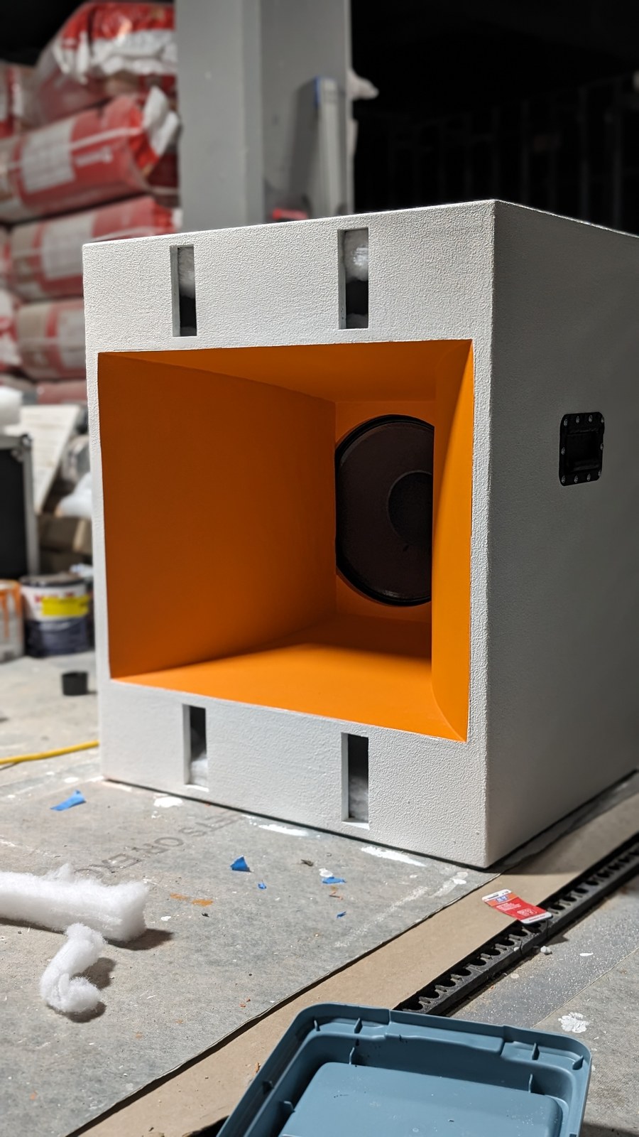 Orange and white speaker cabinet on the workbench during construction